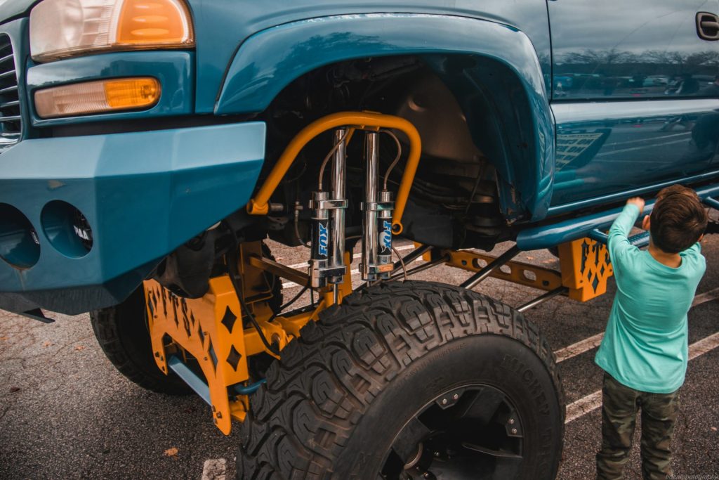 a person standing next to a blue truck
